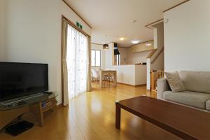 Agarii名護ビーチハウス的客厅配有平面电视和沙发。