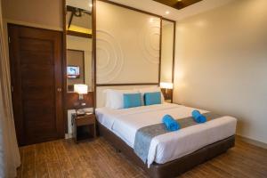 安达Parklane Bohol Resort and Spa的一间卧室配有一张带蓝色枕头的大床