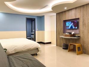 台北水都溫泉會館 的一间卧室配有一张床,墙上配有电视