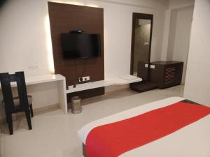 艾哈迈达巴德HOTEL AIRPORT INN ONE的一间卧室配有一张床和一台电视。
