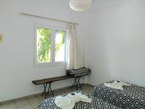 迈洛波塔斯Nissos Ios的一间卧室设有两张床和窗户。