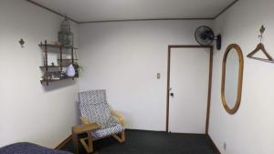 丰中roundabout TOYONAKA的一间房间,配有椅子和一扇带时钟的门