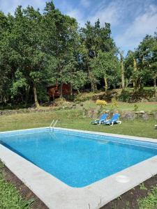 A XesteiraVeiga Mariña的一个带两把椅子的庭院内的游泳池