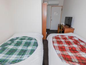 松江市Tabist Hotel Yakumo Matsue的两张睡床彼此相邻,位于一个房间里
