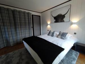 Saint-Nicolas-la-ChapelleChalet Appart'Hôtel l'Eau Vive的卧室配有一张大床,墙上挂着一只公牛