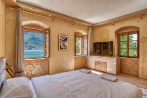 多布罗塔Stone Home Kotor的一间卧室设有一张床、一台电视和窗户。