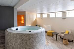 卢瓦尔河畔默恩拉波特德斯查特奥克斯贝斯特韦斯特酒店的一个带椅子和桌子的大浴缸