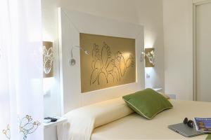 阿尔盖罗ALGHERO NOON的一间卧室配有一张带绿色枕头的床