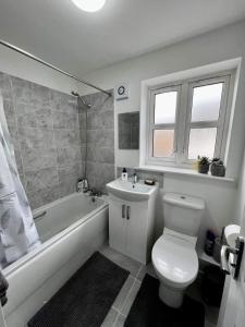 Mile EndNorth Colchester Homestay的浴室配有卫生间、浴缸和水槽。