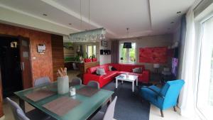 厄尔科Dom na Leszczynowej Górce - plaża, las的客厅配有红色沙发和蓝色椅子