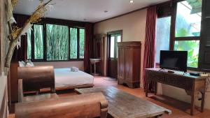 伦邦伊玛塞尼曼酒店的一间卧室配有一张床和一张书桌及电视