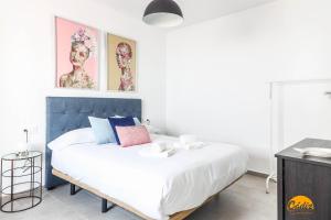加的斯Casa Rehala by Cadiz Time的一间卧室配有一张白色大床和蓝色床头板