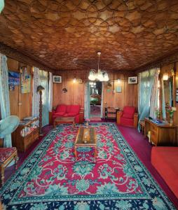 斯利那加Shiraz Deluxe Houseboat的客厅配有红色沙发和地毯。
