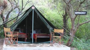 安博塞利马赛辛巴营度假村的配有两把椅子和一张桌子的帐篷和街道标志