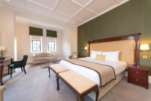 法恩伯勒埃尔夫瑟姆酒店的一间大卧室,配有一张大床和一张书桌