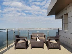 马马亚Ada Luxury Apartments 57的阳台配有三把椅子,享有水景