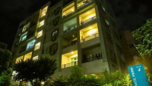 海得拉巴White Fern Stays Serviced Apartments - Gachibowli的夜间有灯的公寓大楼