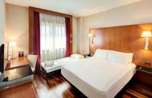 里瓦斯-巴西亚马德里德塞尔科蒂尔AB里瓦斯酒店的酒店客房设有一张白色大床和一张书桌