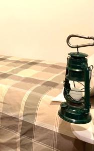 莱德罗Enjoy Ledro B&B的一张绿色灯笼,坐在床上