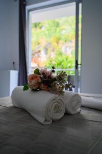 德尔米Ionian Pearl的窗户前地板上带鲜花的毛巾