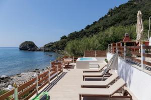 阿齐欧斯·贡多斯Villa Renata & Villa Filippos with private Plunge Pool by Konnect的一个带椅子的阳台和一个游泳池及大海