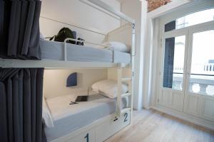 马德里room00 Gran Vía Hostel的客房设有两张双层床和一扇窗户。