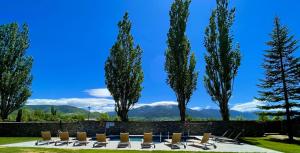 索里谷罗拉丰塔纳尔斯高尔夫酒店的一组椅子和树木,背景是群山
