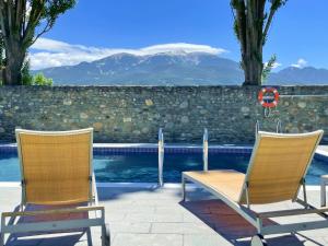索里谷罗拉丰塔纳尔斯高尔夫酒店的游泳池畔的两把椅子和一张桌子