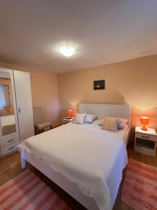 赫瓦尔亚斯纳公寓及客房旅馆 的一间卧室配有一张带两盏灯的大型白色床。