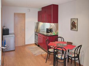 穆尔滕切斯皮奥公寓的厨房配有红色橱柜和红色的桌椅