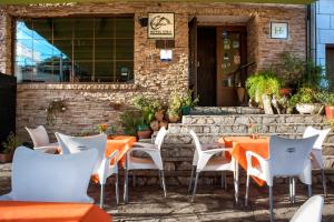 CaminomoriscoHotel Rural Cristania的室外餐厅设有橙色桌子和白色椅子