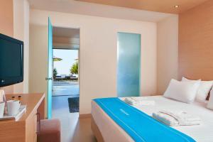古瓦伊The Island Hotel - Adults Only -的一间卧室配有一张床、一台电视和一个阳台