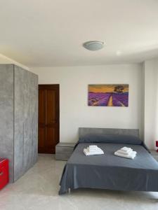 托尔托拉B&B Il Dolce Nido的一间卧室配有一张床,上面有两条毛巾