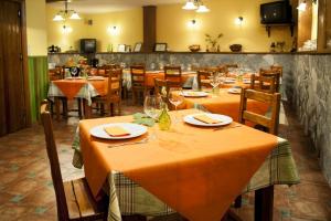 CaminomoriscoHotel Rural Cristania的餐厅配有桌椅和橙色桌布