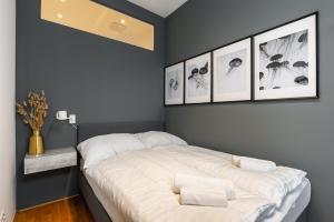 维也纳Trendy apt with - smart TV, coffee machine in Meidling的卧室配有一张四幅画的墙壁床。