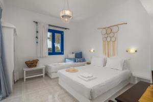 阿达玛斯Anamnisi Studio的白色的卧室设有床和窗户