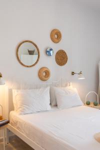 阿达玛斯Anamnisi Studio的白色的床、白色枕头和墙上的镜子