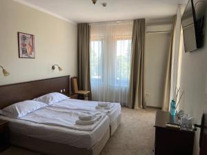 阳光海滩维拉玛丽亚瑞斯酒店的一间卧室配有一张带白色床单的床和一扇窗户。