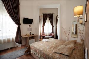 松博特海伊Vinci Apartman Szombathely的一间卧室配有一张床、一张书桌和窗户。