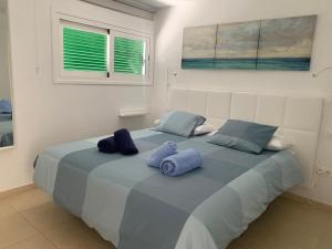 卡门港SEA&RELAX的一间卧室配有一张带蓝色枕头的大床