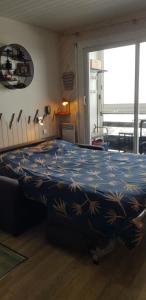 阿雷特studio Batlou ménage inclus的一间卧室配有一张蓝色和黄色毯子的床