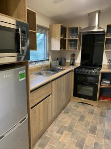 纳尔斯伯勒Nidd Way Holiday Let的厨房配有木制橱柜和不锈钢用具