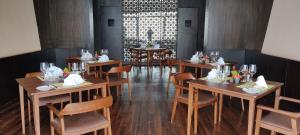 纳加阔特Kavya Resort & Spa的餐厅内带木桌和椅子的用餐室