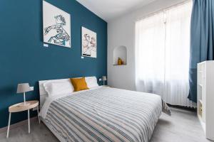 都灵Blunotte Torino - Piazza Arbarello的一间卧室设有一张床和蓝色的墙壁
