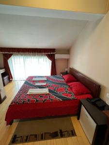 比耶洛波列Hotel Royal的一间卧室配有一张带红色床罩的床和窗户