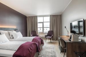 斯彻达尔瓦尔内斯品质机场酒店的配有一张床和一张书桌的酒店客房