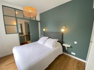 迪纳尔Hotel Saint-Michel的卧室配有白色的床和镜子