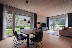 安德马特Andermatt Alpine Apartments的一间带桌椅和沙发的用餐室