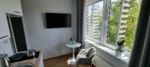 塔尔图Pepleri Studio 68的客房设有带桌子和电视的大窗户。