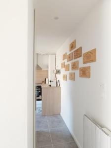 Saint-Médard-de-GuizièresImmeuble Centre Ville的厨房设有白色的墙壁,墙上设有木标志的走廊
